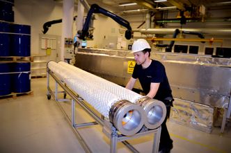 : Armering av røret er gjort klar sammen med innfestingen av stålkobling i endene av røret før Arunas Zemaitis sender det hele til støpeformen. Røret produseres i komposittmateriale etter oppskrifter som er bedriftshemmeligheter. Foto:  Thomas Førde
