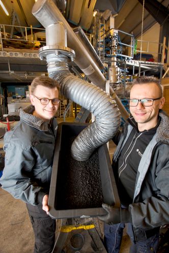 Ny teknologi: Pyrolyse med mikrobølger omdanner cruisesøppel til energi. Her mottar utviklingssjef Asgeir Wien (t.v.) og testingeniør Marek Tomczyk fra Scanship trekull på sluttstasjonen. foto: Håvard Solerød