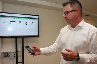 Via en App på telefonen får Aleksander Mortensen og brukere i Australia opp oversikt over nærmeste returpunkt, tilstanden og hvor mye de har pantet for. På TV-skjermen vises dashboard med detaljert informasjon i sanntid for en automat i Australia. Foto:  Tore Stensvold