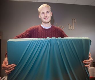 Bjørn Lorentzen med krummemadrassen som er både støt og sprutsikker. Den skal også kunne benyttes i senga hjemme. Foto:  Alf Bergin