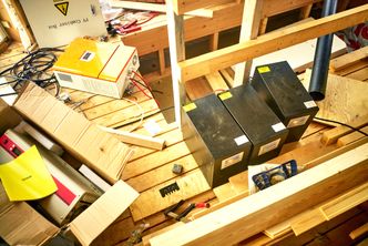 Loftsrommet på huset der batterier er skjult under gulvet. I forgrunnen står omformere. Wegge planlegger en egen bygning til batteriene for å minimere brannfaren. Foto: Eivind H. Natvig