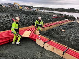 Fundamentet under kaier og oppstillingsplass blir bygget opp med flere tykke lag av pukk og singel med betongstein som toppdekke, til sammen 140 cm med spesifiserte masse. Under det hele legges mange kilometer med trekkerør for elkabler. Foto:  Vassbakk og Stol