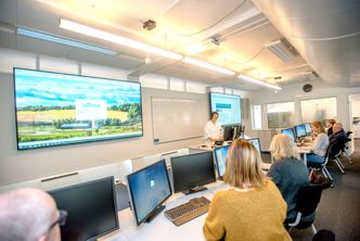 Her, i IT-brakka, på området til St.Olavs Hospital vil det være fullt opp av folk fra høsten 2019. Her skal IT-folk og klinikere jobbe side om side med utviklingen. Foran de store skjermene står kreftlege Nina Kongshaug Foto:  Havard Zeiner