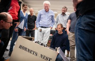 Petter Muren (i midten) studerer «Hornet's Nest», et automatisk innfangingssystem for droner, som fire studenter konstruerte i sommer. Foto: Eirik Helland Urke