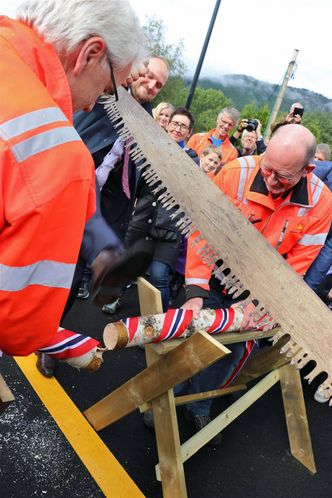 Samferdselsminister Jon Georg Dale må til slutt ta beinet til hjelp og sparke vegen åpen. Til venstre prosjektleder Odd Helge Innerdal, til høyre byggeleder Terje Anundsen. Foto:  Statens vegvesen
