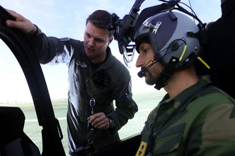 Kronprins Haakon får innføring i F-35-simulatoren av Thomas Harlem, sjef for TTT-skvadronen. Foto:  Forsvaret