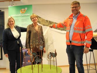Ordfører Bente Elin Lilleøkseth i Løten, kunster Elin Drougge og assisterende prosjektleder Arne Meland fra Statens vegvesen avduker modellen av kunstverket. Foto:  Bjørn Olav Amundsen