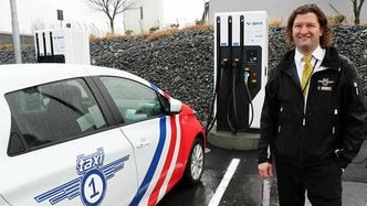– I dag er jeg her med en flunkende ny Renault som går 30 mil per lading. Da trenger jeg bare å lade den én gang i døgnet, sier Robert Aasmul, daglig leder i Taxi1. Foto: Vestland fylkeskommune