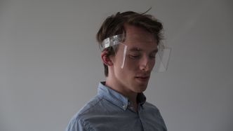 Hågen Toverud viser hvordan brillene festes med et bånd rundt hodet, og dermed kan tilpasses den enkeltes hodeform. Foto: Eik idéverksted