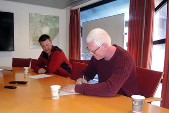 Leder Johan Dag Drange undertegner Tovdal-Myklandskontrakten for drift og vedlikehold i Agder fylkeskommune Driftsleder Simon Heddeland skal ha det daglige ansvaret for drift og vedlikehold i denne kontrakten. Foto:  Agder fylkeskommune