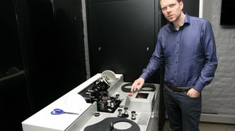Ole Liabø viser fram skriveren, hvor dataene lagres som en 2D-strekkode i hver av rammene til filmen. Foto: Harald Brombach