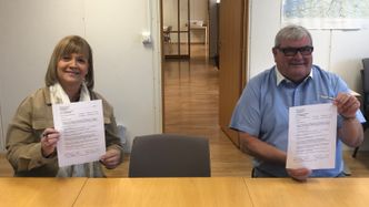 Hilde Alice Kvernrød, prosjektsjef i Mesta AS, og Arild Lars Hamrum-Norheim, seksjonsleder i Trøndelag fylkeskommune, signerer kontrakten om drift og vedlikehold av vegnettet i Trondheim de neste åtte årene. Foto: Trøndelag fylkeskommune