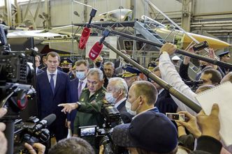 Forsvarsminister Sergej Sjojgu (grønn uniform) på en pressekonferanse på Sukhoi-fabrikken onsdag, med en Su-57 i bakgrunnen. Foto:  UAC