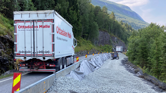 En kjørebane holdes åpen. Dette vogntoget har akkurat tømt Glasopor fra hengeren i den ene enden av grøfta og lasset på bilen i den andre.
