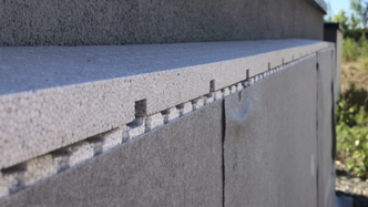 En topplist med fall monteres på toppen, og en overgangslist oppå denne. Slik sikres fall vekk fra muren for regnvann. Foto: Bewi