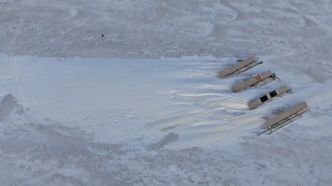 Dronefoto viser størrelsen på snøfonnene i forhold til anlegget (en rad i anlegget er 10 m lang). Foto: UNIS