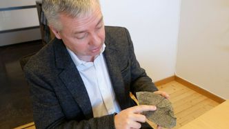 Denne steinen har Francois Renard funnet nord for Bergen. Den svarte linjen har oppstått under et jordskjelv for millioner av år siden. Foto:   Eivind Torgersen/UiO