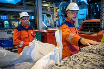 Høyanger, og Hydros øvrige aluminiumverk i Norge, utvikler nå metoder for å anvende brukt aluminium direkte i produksjonen av ny aluminium. Fabrikksjef Arne-Martin Kjærland og Helge Vadheim viser frem brukte høyspentledninger som er klare for resirkulering. Foto: Halvor Molland