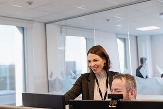 Anders Bergman, som har sin tredje dag i ny jobb, får opplæring i COWIs timeføringssystem fra Ingrid Gabrielsen Klokk. De er tidligere kolleger fra Equinor. Foto: Ragnhild Heggem Fagerheim/COWI