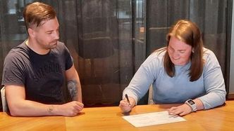 Byggeleder Trøndelag fylkeskommune Lars Wiseth Ness og prosjektleder Winsnes Maskin og Transport AS, Kari Anne Endal, signerer kotrakten. Foto: Trøndelag fylkeskommune
