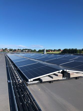 Solcellene ligger med ti graders helling på stativer som holdes nede med betongheller – en svært kostnadseffektiv måte å installere solceller på flate tak. Foto: Solcellespesialisten