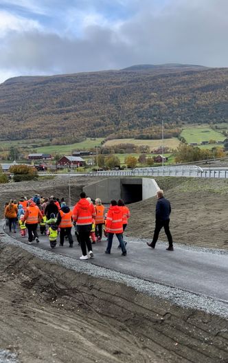 Den formelle åpningen ble gjennomført ved at barn og unge fra oppvekstsenteret gikk sammen med ordfører, entreprenør og Statens vegvesen i tog gjennom den nybygde kulverten. Foto:  Statens vegvesen