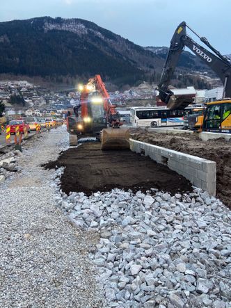 Entreprenør Kveen er i gang med det rotvennlige forsterkningslaget, som skal gi riktige vekstforhold for trærne som plantes. Foto: Statens vegvesen
