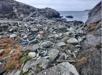 Slik så det ut i en av vikene før oppryddingen startet. Årevis med søppel fra havet har samlet seg i store hauger. Foto:  Vestland fylkeskommune