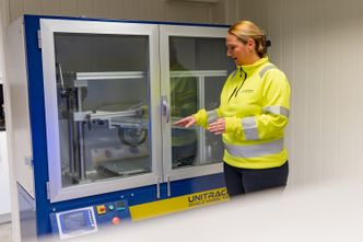 Helene forklarer hvordan maskinen kan simulere slitasje på vei ved at et hjul kjøres over en asfaltprøve. Foto: TUM Studio