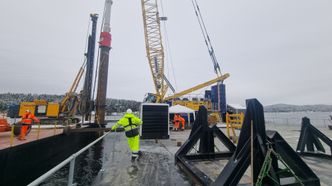 Til venstre i bildet ser vi at pelen slås ned et stykke på vei ved hjelp av hammeren. Krana holder hammeren slik at den ikke tipper over ende. Foto: Cowi