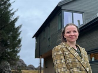 Ingvill Storøy ved huset der hun bor og har hjemmekontor. Foto: privat