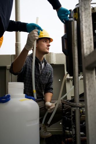 Her fyller Jesper Nilsen Negård tankene med vann fra fjorden. På tokt er alle prøver nøye planlagt og følger et stramt tidsskjema. Foto:  Elina Melteig/UiO