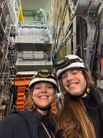 Inga Strümke (t.h.) studerte hvordan data fra eksperimenter som Atlas (i bakgrunnen) ville sett ut dersom det finnes mer enn ett Higgsboson. Her er hun sammen med Eli B. Rye fra Norsk senter for CERN-relatert forskning Foto: Privat