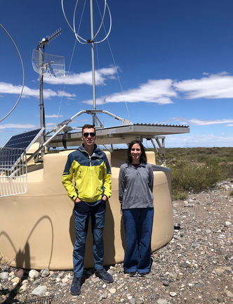 Domenik Ehlert og Foteini Oikonomou foran en av de 1600 overflatedetektorene som hører til Pierre Auger Ultra-high Energy Cosmic Ray Observatory i Malargue i Argentina. Foto: Privat