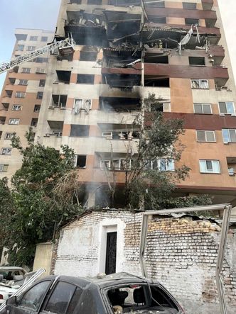 Brannmenn jobber ved en boligblokk i Teheran etter at den ble truffet i av israelske angrep. Foto: AP Photo/Vahid Salemi