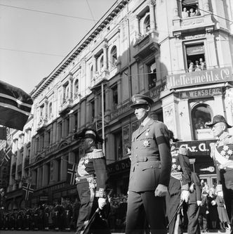 Kong Olav V og daværende kronprins Harald V avbildet ved Stortorvet på Karl Johan i Oslo under Kong Haakon VIIs gravferd 1. oktober 1957. Foto: Robert Charles Wilse/Oslo Museum/CC-BY-SA-4.0