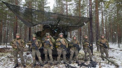 Bildet viser norske soldater i kamuflasjeuniform og med våpen på øvningsfeltet ved Rena militærleir.
