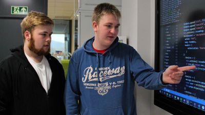 Ole Mathias Gullvåg (t.v) og Daniel Christensen ser på en skjerm som blant annet viser kildekode.