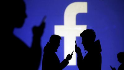 Silhuetter foran Facebooks logo.