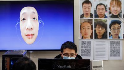 De fleste kinesere bruker nå munnbind utendørs på grunn av koronaviruset (Covid-19). En utvikler i selskapet Hanwang Technology jobber på ansiktsgjenkjenningssystemet som kan identifisere også maskerte mennesker. Bildet er tatt av Reuters 6. mars 2020.
