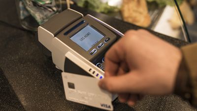 En kunde bruker et Visa-kort i en betalingsterminal.