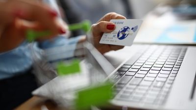 Bankkort og handlekurv foran en bærbar pc.