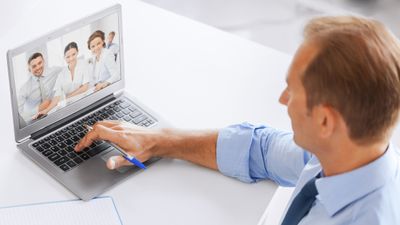 Forretningsmann som har videomøte på en bærbar PC.