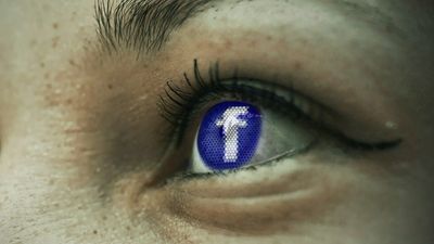 Facebook-logoen vises i øyet på en person.