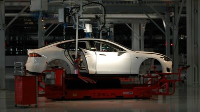 Et skall av en tesla på en maskin i produksjonslinjen i en fabrikk