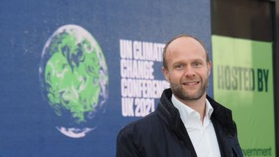 Mann foran en vegg med bilde av jordkloden