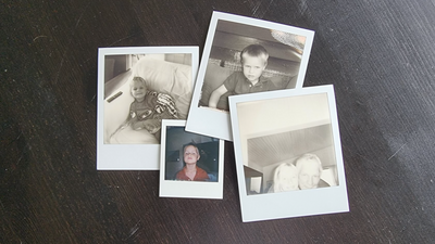 Gamle polaroidbilder i bunke på et bord.