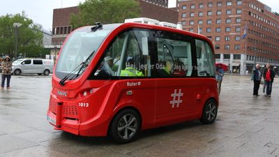 Rød, selvkjørende buss foran Oslo rådhus.