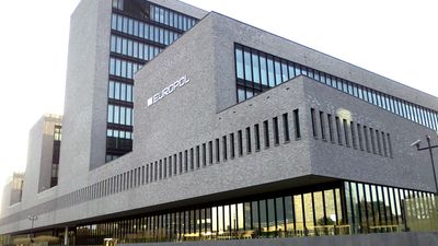 En grå mursteinsbygning med logoen til Europol på veggen
