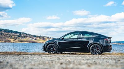 Tesla modell Y med vann i bakgrunnen